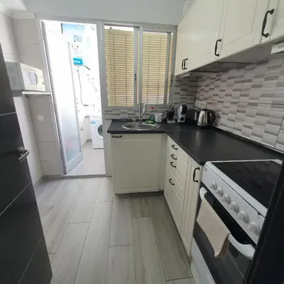 a small kitchen with a sink and a stove at Apartamento Berenguer in Cullera