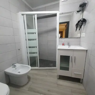 a bathroom with a toilet and a sink and a mirror at Apartamento Berenguer in Cullera
