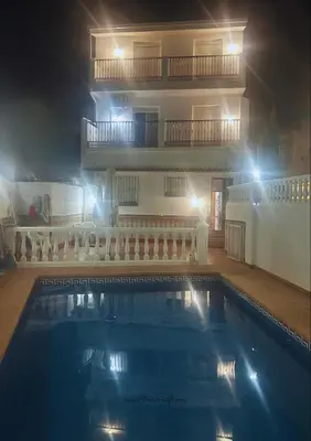 a swimming pool in front of a building at night at El Siprer in Anna