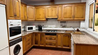 a kitchen with wooden cabinets and a white microwave at El Siprer in Anna