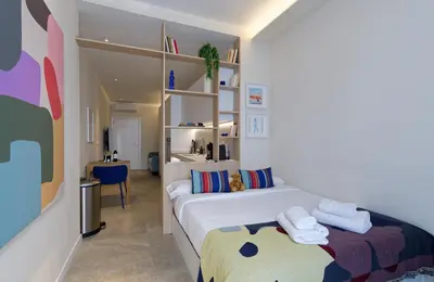 a bedroom with a large white bed and a desk at Osito Hub - Justo y Pastor in Valencia