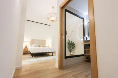 a hallway with a mirror and a bedroom with a bed at Roca 26 in Valencia