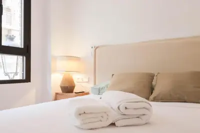 a white bed with two towels on it at Roca 26 in Valencia