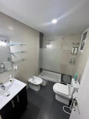 a white bathroom with a toilet and a sink at Departamento en Torrent in Torrent
