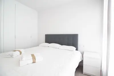 a white bedroom with a large bed with white sheets at Gran Canet Vlado in Canet de Berenguer