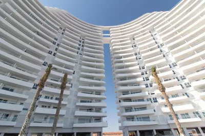two tall white buildings with palm trees in the foreground at Gran Canet Vlado in Canet de Berenguer