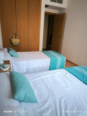 two beds in a hotel room with blue pillows at Apartamento Masia Racó Cullera in Cullera