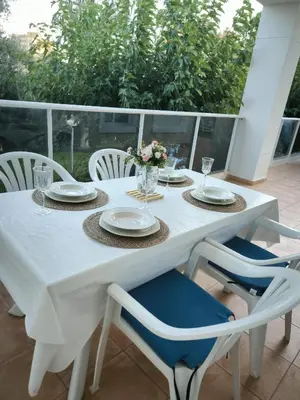a white table with chairs and plates and flowers on it at Apartamento Masia Racó Cullera in Cullera