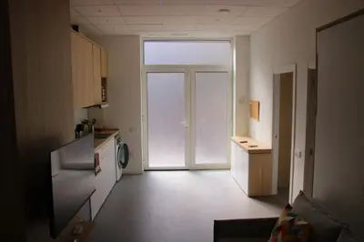 a kitchen with a door leading to a kitchen with a refrigerator at Flats Benimaclet in Valencia
