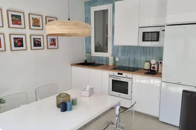 a kitchen with white cabinets and a white counter top at Romantic Apartment in Cabanyal by Virkin Suites in Valencia
