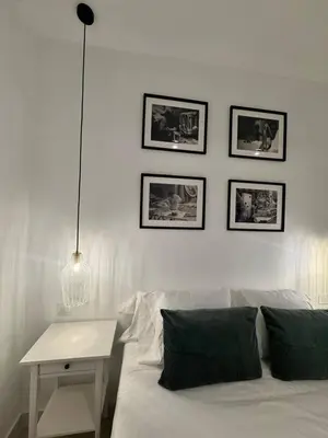 a white couch with a table and pictures on the wall at Romantic Apartment in Cabanyal by Virkin Suites in Valencia