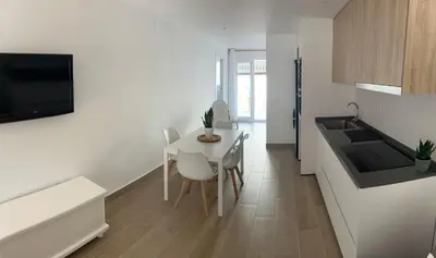 a white kitchen with a table and chairs in it at vivienda independiente in Canet de Berenguer