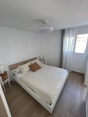 a white bedroom with a bed and a window at vivienda independiente in Canet de Berenguer