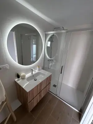 a bathroom with a sink and a shower with a mirror at vivienda independiente in Canet de Berenguer