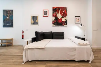a bed in a room with paintings on the wall at La casa de la pintora by Concept Flats in Valencia