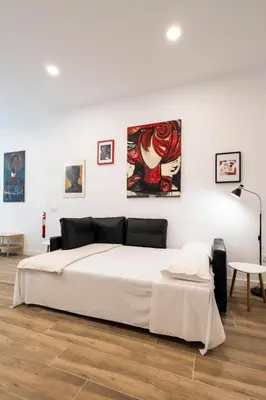 a bedroom with a large bed and paintings on the wall at La casa de la pintora by Concept Flats in Valencia