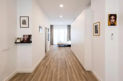 an empty hallway with white walls and wood floors at La casa de la pintora by Concept Flats in Valencia