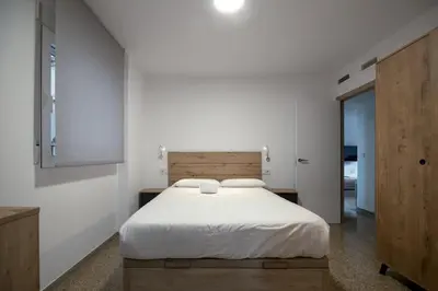 a bedroom with a white bed and a wooden headboard at GuestReady - Valencia Bliss near Malvarrosa Beach in Valencia