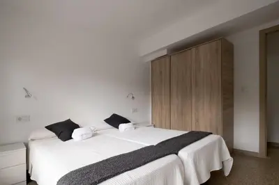 a bedroom with a white bed and a wooden cabinet at GuestReady - Valencia Bliss near Malvarrosa Beach in Valencia