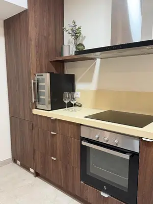 a kitchen with a microwave and two wine glasses at Apartamento con increíbles vistas a la bahía de Cullera in Faro de Cullera
