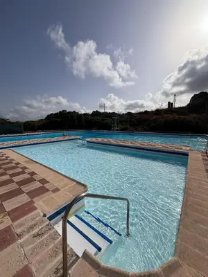 a large swimming pool with blue water at Apartamento con increíbles vistas a la bahía de Cullera in Faro de Cullera