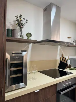 a kitchen with a stove and two wine glasses at Apartamento con increíbles vistas a la bahía de Cullera in Faro de Cullera
