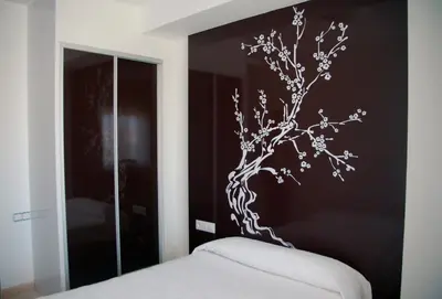 a bedroom with a black wall with a tree mural at Sol Playa in Valencia