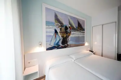 a bedroom with a painting on the wall above a bed at Sol Playa in Valencia