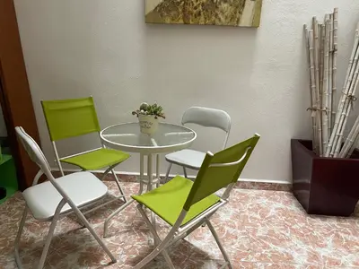 a table with four chairs and a table with a plant at Acogedora planta baja in Benaguacil