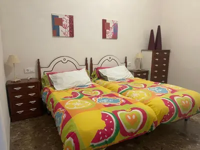 a bedroom with a bed with a colorful blanket at Acogedora planta baja in Benaguacil