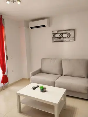 a white living room with a table and a couch at Perla del mar in Moncófar
