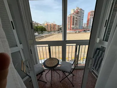 a balcony with a table and chairs and a view of a field at Apartments del sol in Cullera