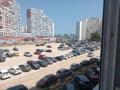 a parking lot full of cars in a city at Apartments del sol in Cullera