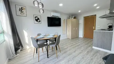 a dining room with a table and chairs and a kitchen at Versus Apartments near City of Arts III in Valencia