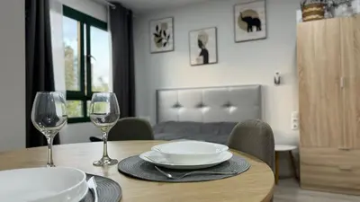 a wooden table with two wine glasses and a plate at Versus Apartments near City of Arts III in Valencia