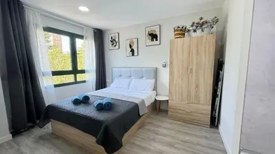 a bedroom with a bed with two blue towels on it at Versus Apartments near City of Arts III in Valencia