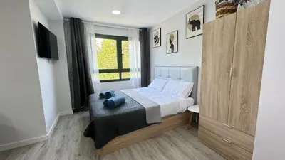 a small bedroom with a bed and a window at Versus Apartments near City of Arts III in Valencia