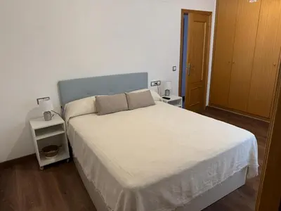 a bedroom with a white bed with two night stands at Casa Emma in Burriana