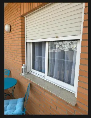 a window in a brick house with a table and chairs at Casa Emma in Burriana