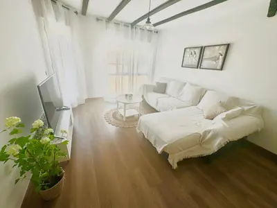 a white living room with a couch and a table at Casa Emma in Burriana