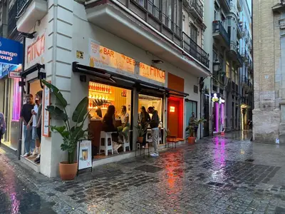 a group of people standing outside a store on a street at Turia Gardens Rooms - Authentic Valencia Downtown Parklife - VLC Urban Rental in Valencia