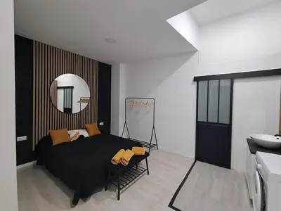 a bedroom with a black bed and a mirror at Anthracita in Valencia