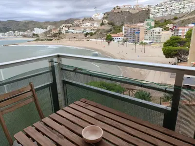 a wooden bench on a balcony with a view of a beach at Seaviews Los Olivos in Cullera