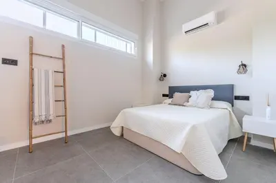 a white bedroom with a bed and a window at La Suite Mediterránea - Housevanlive in Valencia