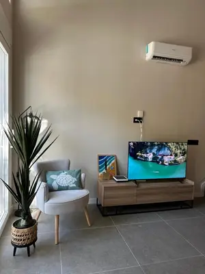 a living room with a flat screen tv and a chair at La Suite Mediterránea - Housevanlive in Valencia