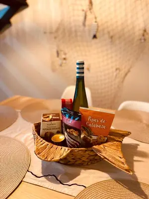 a basket of food and a bottle of wine on a table at La Suite Mediterránea - Housevanlive in Valencia