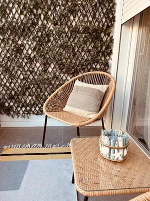a wicker chair sitting on a porch with a table at La Suite Mediterránea - Housevanlive in Valencia