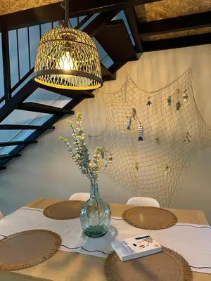 a table with a glass vase with flowers in it at La Suite Mediterránea - Housevanlive in Valencia
