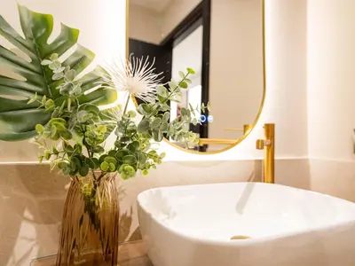 a bathroom with a vase of flowers and a mirror at MD Nou Mestalla in Valencia