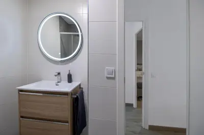 a white bathroom with a sink and a mirror at Apartment in El Mercat in Valencia